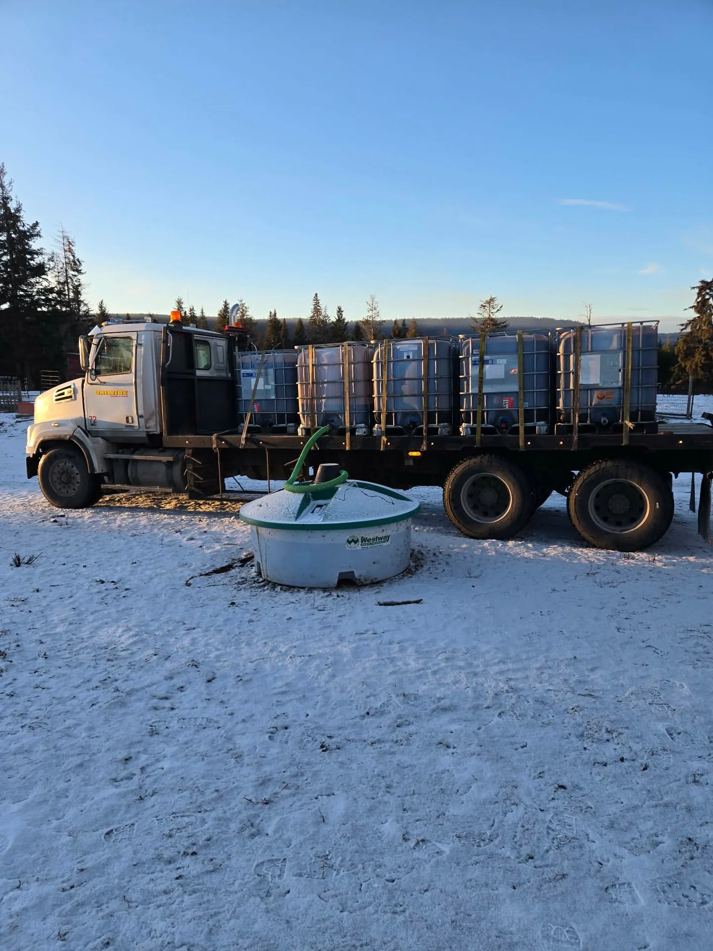 Flatbed truck with liquid feed totes — winter delivery